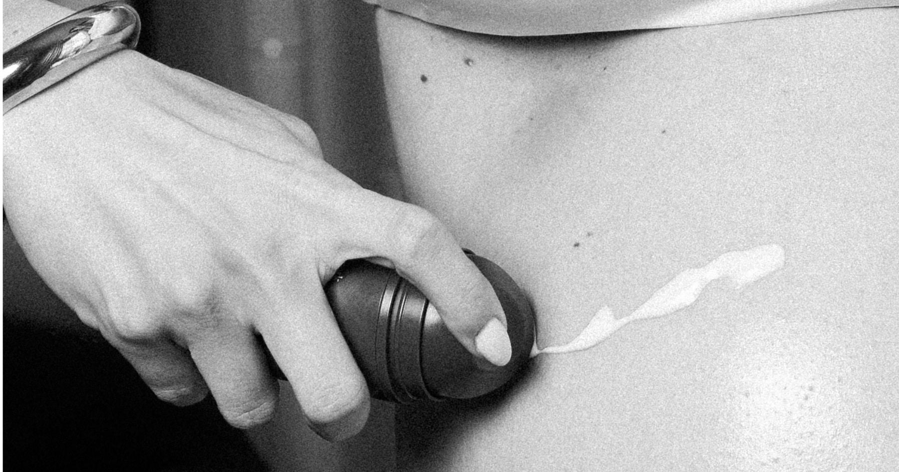 A pregnant women applying In Season Stretch Shield on belly
